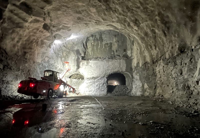 En maskin står i ena änden av en tunnel framför två mindre öppningar.