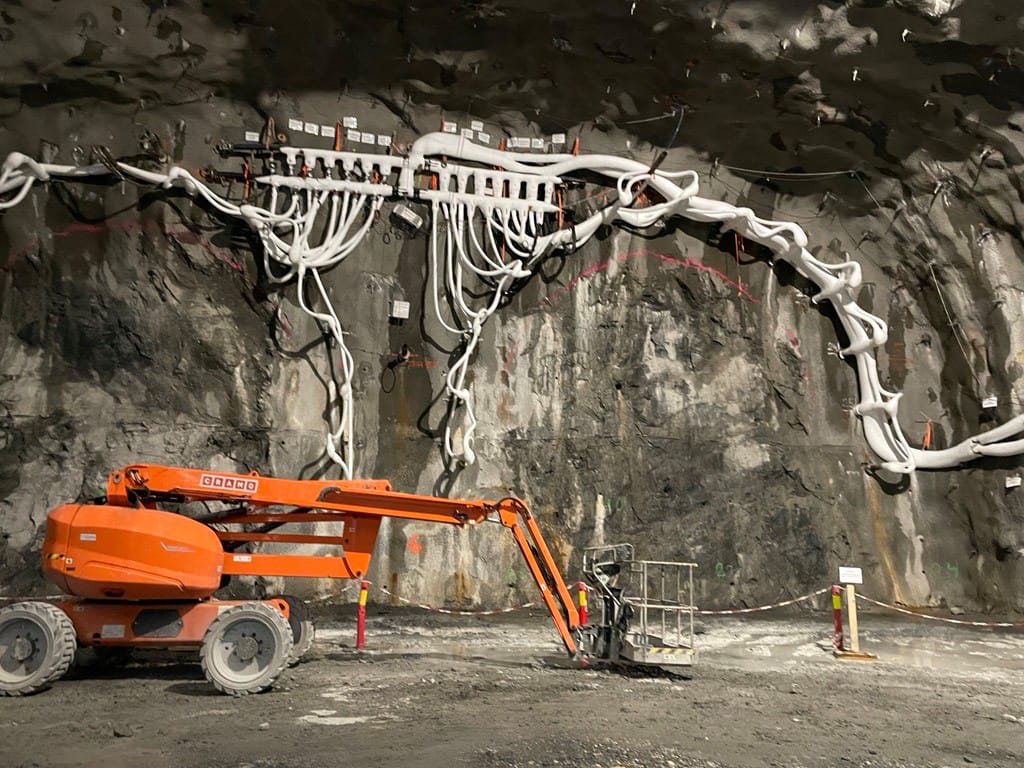 Frostiga rör hänger framför en bergvägg.